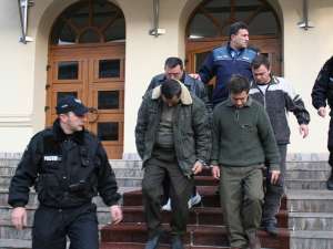 Foto: Babalean, cel cu ochelari, şi o parte dintre complicii săi, pe treptele Palatului de Justiţie, escortaţi de poliţiştii de la Arest